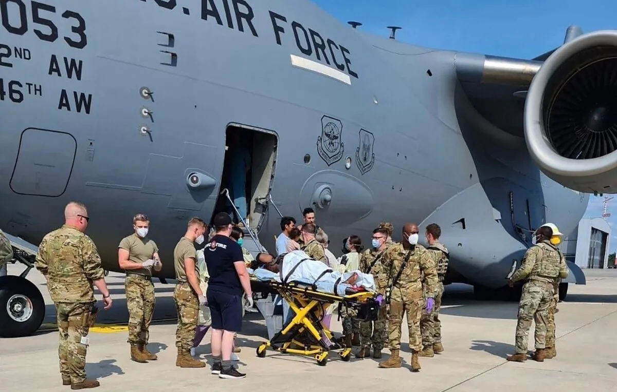 Medical support personnel help an Afghan mother and family off a U.S. Air Force C-17, moments after she delivered a child aboard the aircraft upon landing at Ramstein Air Base, Germany, on Aug. 21, 2021. (U.S. Air Mobility Command via Reuters)