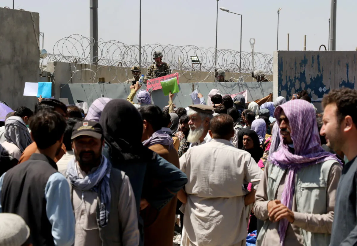 Crowds of people show their documents to U.S. troops outside the airport in Kabul, Afghanistan on Aug. 26, 2021. (Stringer/Reuters)