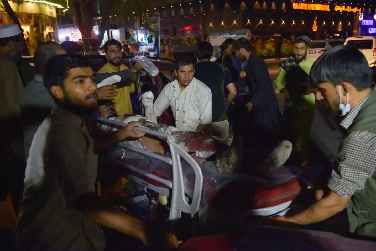 Volunteers and medical staff bring an injured man on a stretcher for treatment after explosions outside the airport in Kabul, Afghanistan, on Aug. 26, 2021. (Wakil Kohsar/AFP via Getty Images)