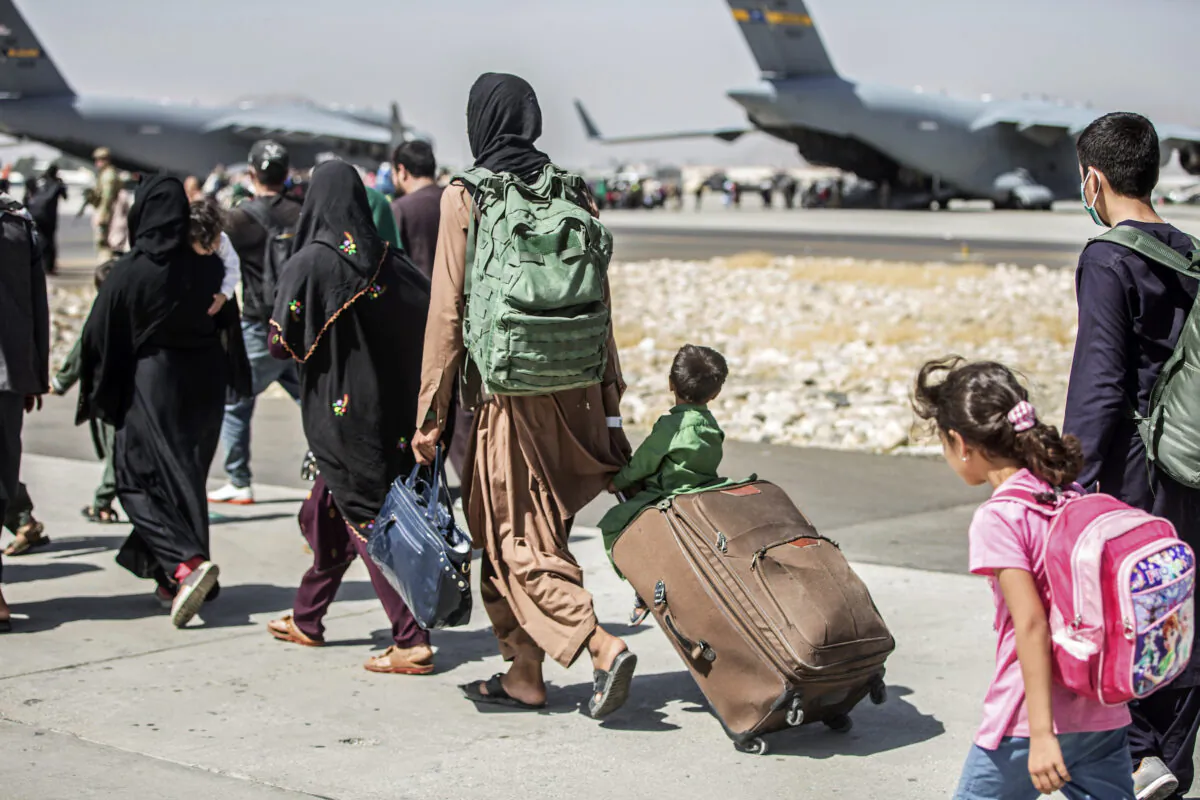 Families walk towards their flight during ongoing evacuations at Hamid Karzai International Airport, Kabul, Afghanistan, on Aug. 24, 2021. (Sgt. Samuel Ruiz/U.S. Marine Corps via AP)