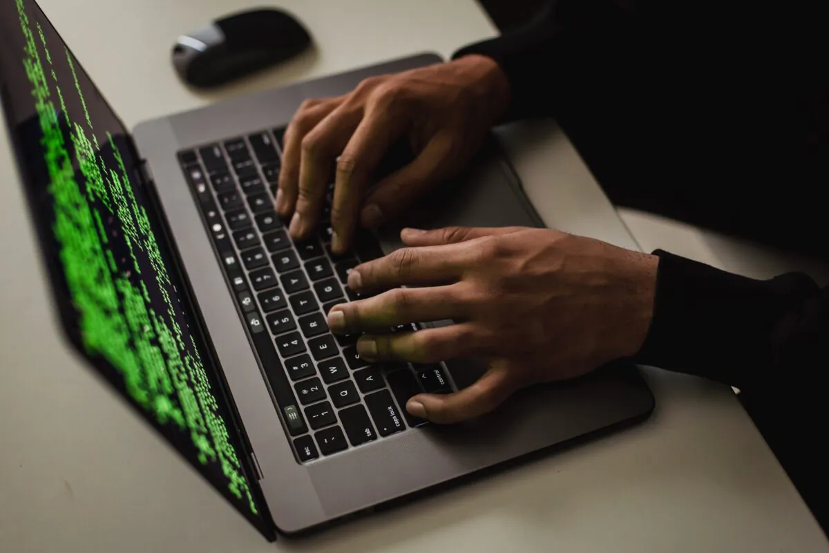 Crop cyber spy hacking system while typing on laptop. (Sora Shimazaki/Pexels)