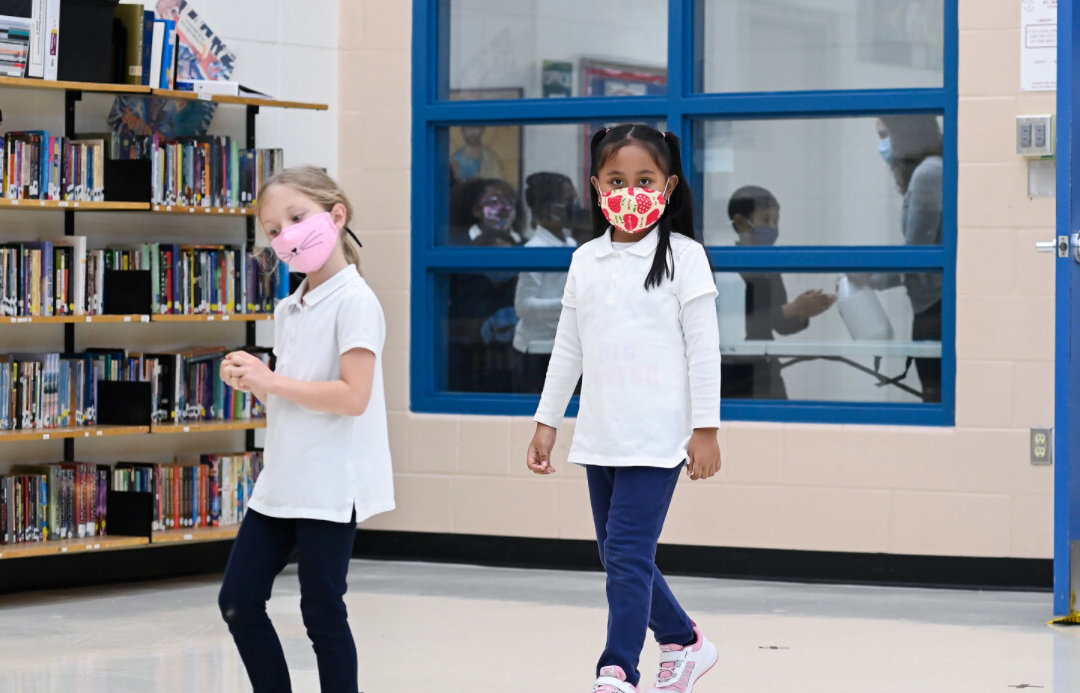 Children arrive in line using physical distancing before getting their picture taken at picture day at St. Barnabas Catholic School during the COVID-19 pandemic in Scarborough, Ont., on Oct. 27, 2020. (THE CANADIAN PRESS/Nathan Denette)