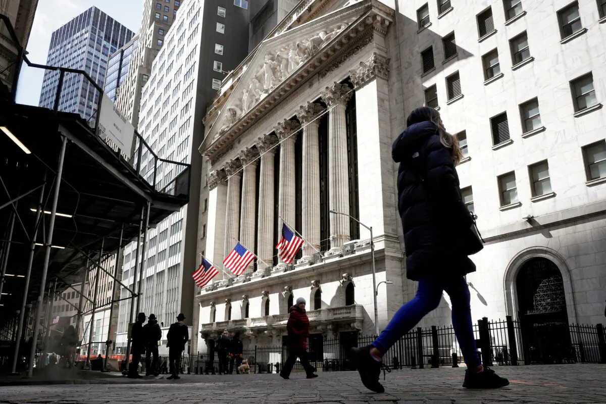 People are seen on Wall Street outside the New York Stock Exchange (NYSE) in New York City, on March 19, 2021.  (Brendan McDermid/Reuters)