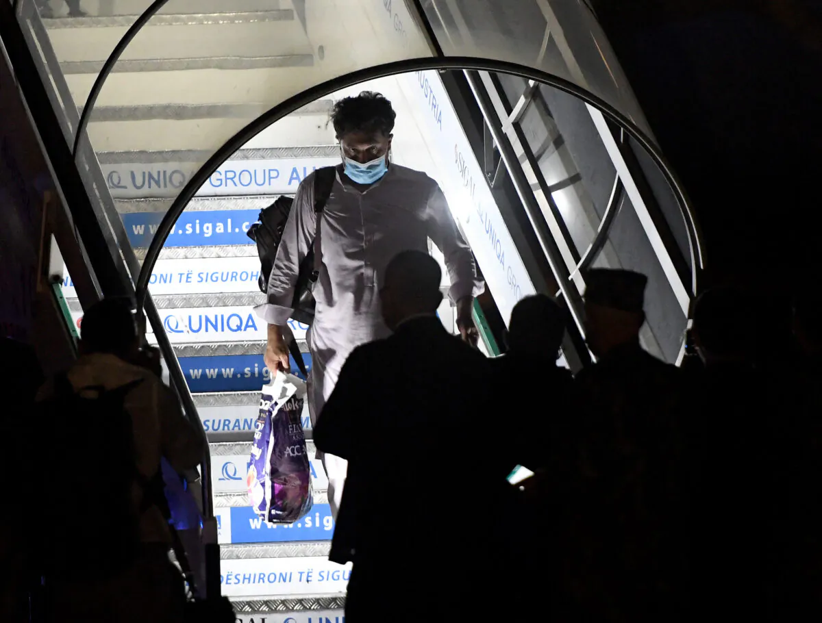 An Afghan man leaves a plane as people arrive from Afghanistan with an evacuation flight at Rinas Airport in Tirana, Albania, on Aug. 27, 2021. (Gent Shkullaku/AFP via Getty Images)