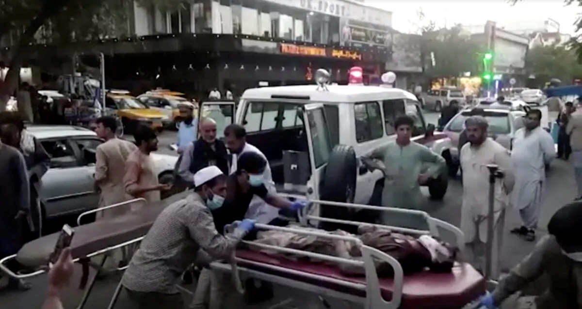 A screen grab shows people carrying an injured person to a hospital after an attack at Kabul airport, in Kabul, Afghanistan, on Aug. 26, 2021. (Reuters TV/1TV/Handout via Reuters)