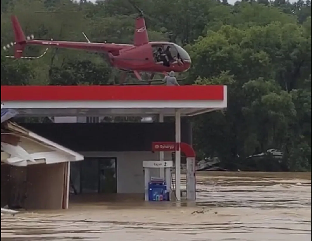 Nashville-based helicopter pilot Joel Boyers rescuing people from a rooftop, in Waverly, Tenn., on Aug. 21, 2021. (Jeani Rice-Cranford via AP)