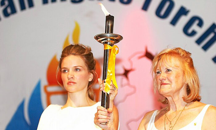 Olympic silver-medalist Jan Becker (R) as Australian ambassador for the Global Human Rights Torch Relay with the "Goddess of Justice" holding up the Human Rights Torch in Federation Square, Melbourne, Australia, on Nov. 16, 2007. The relay called to move the Beijing 2008 Olympic Games due to China's appalling human rights record. (Courtesy of Minghui.org)