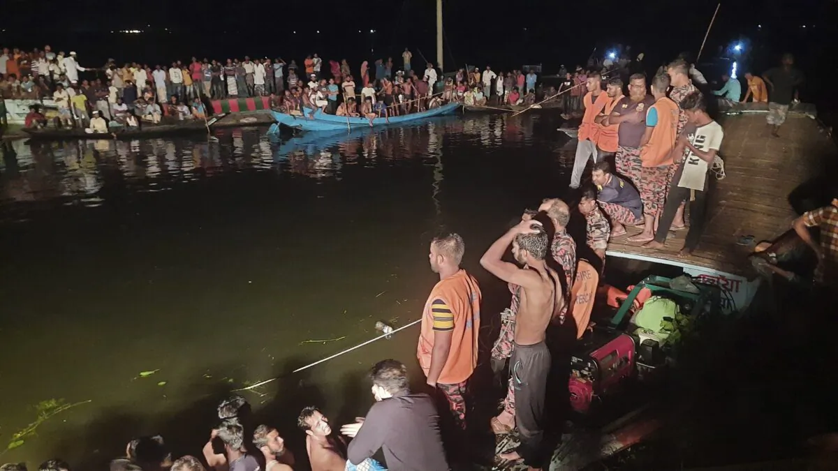 People watch rescue work after a passenger boat carrying more than 100 people sank after a collision in a large pond in Brahmanbaria district, Bangladesh, on Aug. 27, 2021. (AP Photo)