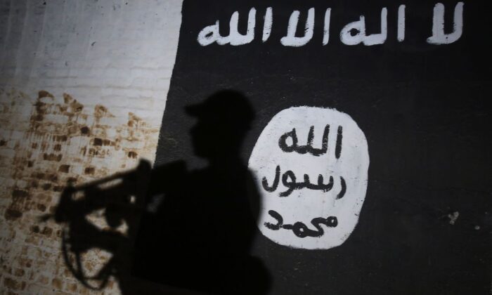 Na muralu widnieje logo grupy terrorystycznej ISIS. (Ahmad Al-Rubaye/AFP via Getty Images)