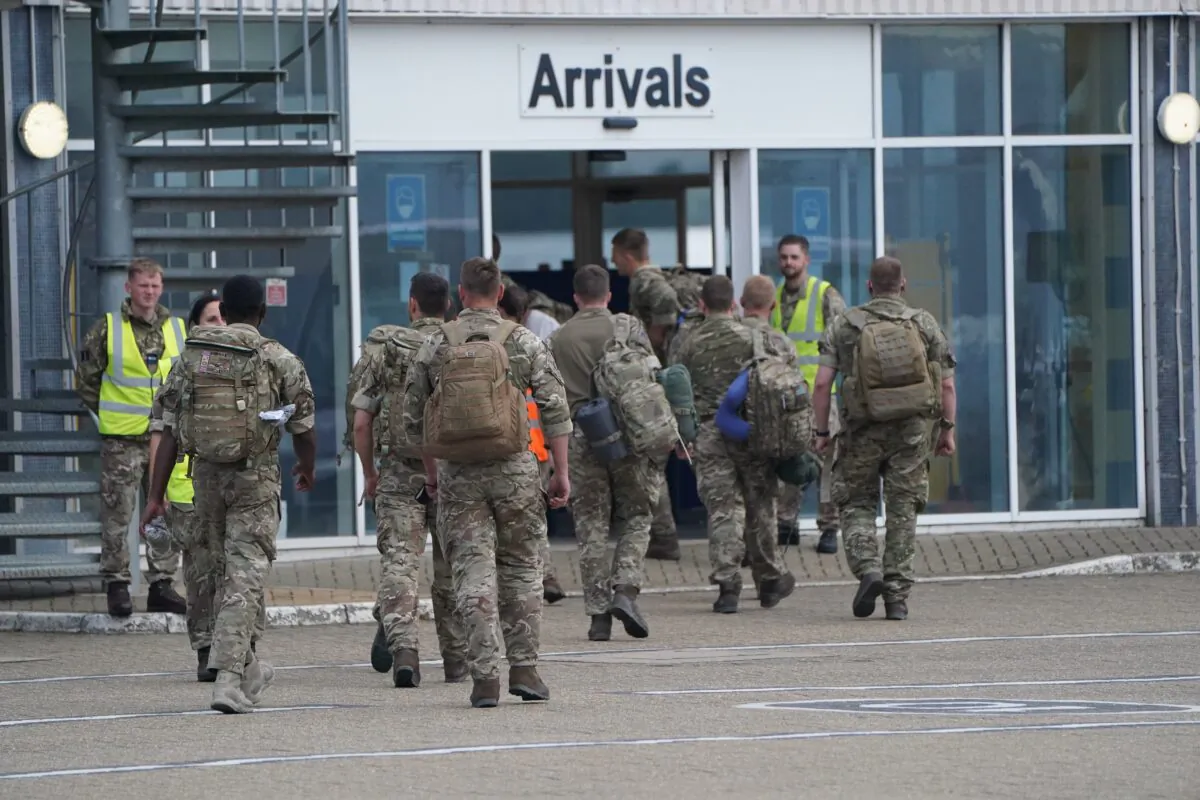 Members of the British armed forces 16 Air Assault Brigade walk to the air terminal after departing a flight from Afghanistan at RAF Brize Norton, in Oxfordshire, UK, on Aug. 29, 2021. (Jonathan Brady/PA)