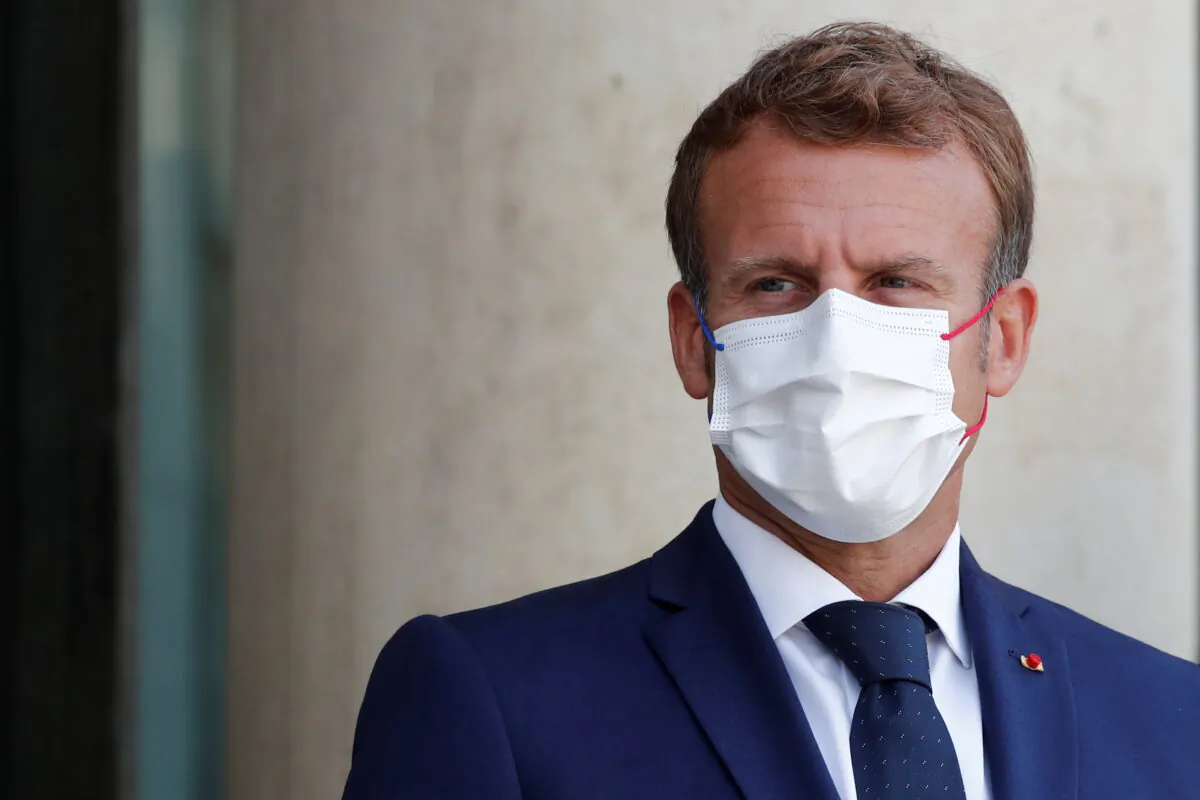 French President Emmanuel Macron, wearing a protective face mask, waits for the arrival of Madagascar's President Andry Rajoelina (not seen) at the Elysee Palace in Paris, France, on Aug. 27, 2021. (Benoit Tessier/Reuters)