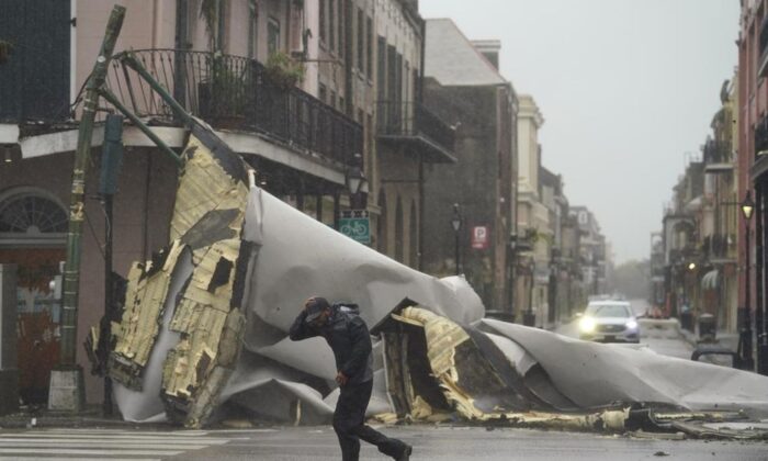 A man passes by a section of roof that was blown off of a building in the French Quarter by Hurricane Ida winds, Sunday, Aug. 29, 2021, in New Orleans. (AP Photo/Eric Gay) 