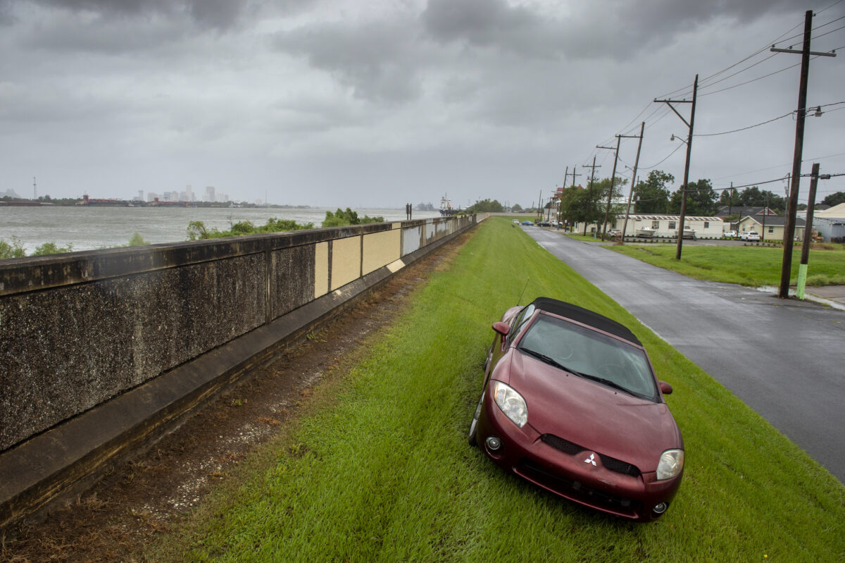 Seeking higher ground from flooding, a car is parked on the Mississippi River levee just downriver from New Orleans, back left, as Hurricane Ida arrives in Louisiana on Aug. 29, 2021. (Chris Granger/The Advocate via AP)