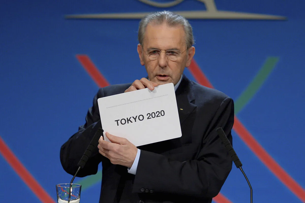 International Olympic Committee (IOC) President Jacques Rogge shows the name of the city of Tokyo elected to host the 2020 Summer Olympics in Buenos Aires, Argentina on Sept. 7, 2013. (Fabrice Coffrini/Pool photo via AP)
