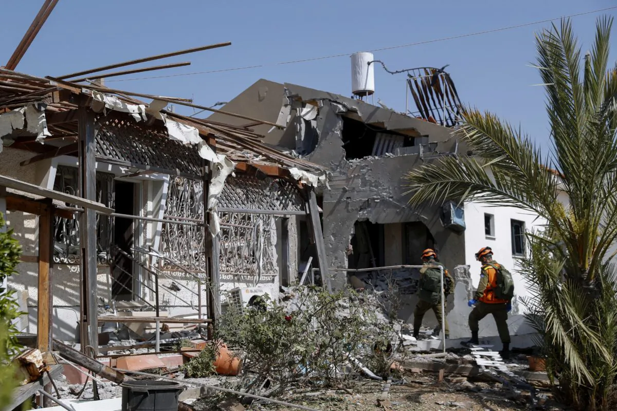Israeli soldiers inspect homes destroyed by a missile fired from the Gaza Strip in the southern Israeli city of Ashkelon on May 11, 2021. (AP Photo/Ariel Schalit)