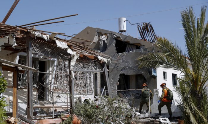 Israeli soldiers inspect homes destroyed by a missile fired from the Gaza Strip, in the southern Israeli city of Ashkelon on May 11, 2021. (AP Photo/Ariel Schalit)