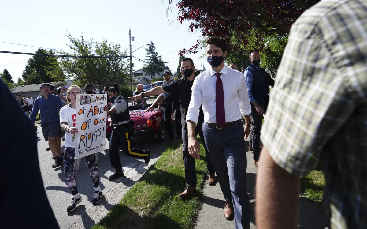 A protester yells at Liberal Leader Justin Trudeau as he makes his way to a motorcade in Surrey, B.C., on Aug 25, 2021. (Sean Kilpatrick/The Canadian Press)