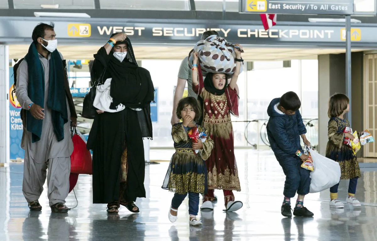 A family evacuated from Kabul, Afghanistan walks through the terminal at Washington Dulles International Airport in Chantilly, Va., on Aug. 30, 2021. (AP Photo/Jose Luis Magana)