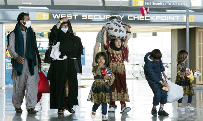 A family evacuated from Kabul, Afghanistan walks through the terminal at Washington Dulles International Airport in Chantilly, Va., on Aug. 30, 2021. (AP Photo/Jose Luis Magana)