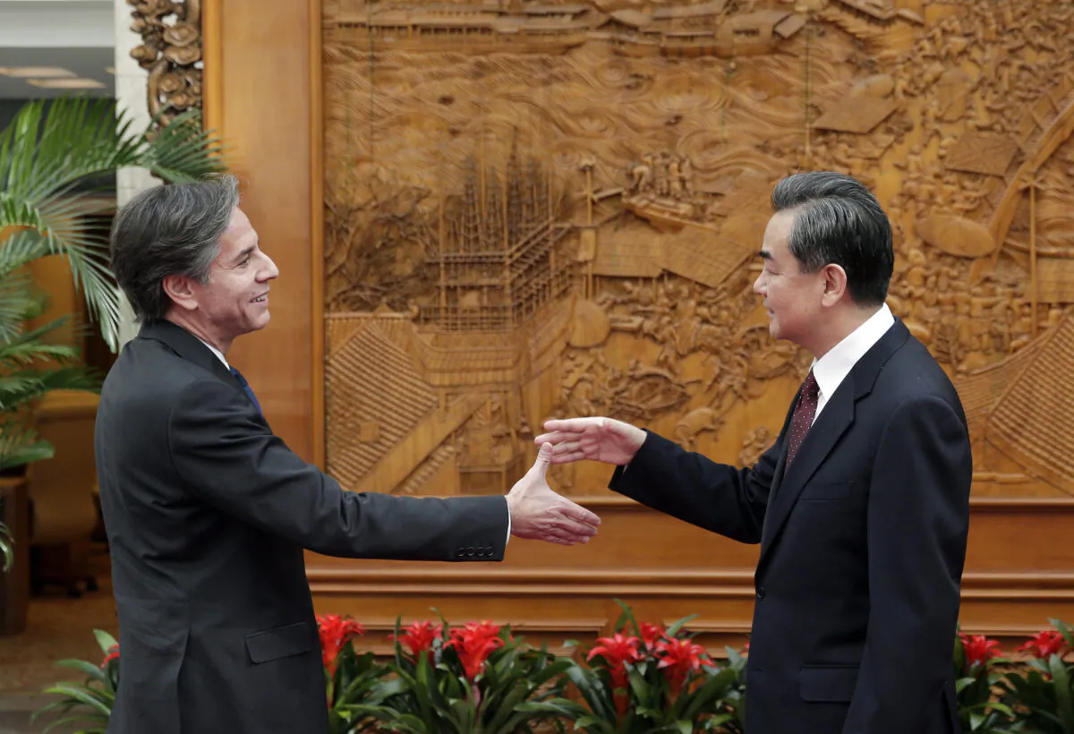 Antony Blinken, who was then-U.S. Deputy Secretary of State (L), shakes hand with China's foreign minister Wang Yi at the Olive Hall before a meeting at the Chinese Foreign Ministry office in Beijing on Feb. 11, 2015. (Andy Wong-Pool/Getty Images)