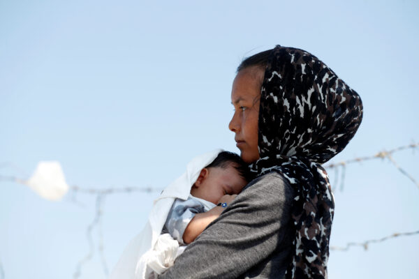 An Afghan woman and her month-old son are seen outside the new temporary camp for migrants and refugees on Lesbos island