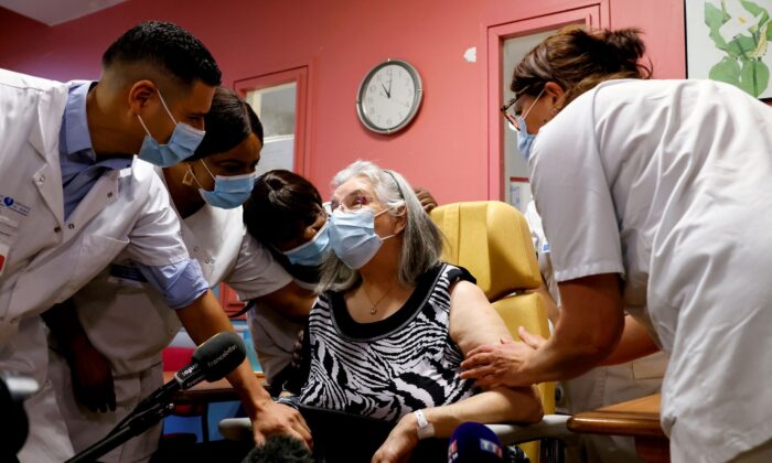 Health workers speak with Mauricette, a 78-year-old French woman, after she received the first dose of the Pfizer-BioNTech COVID-19 vaccine in the country, at the Rene-Muret hospital in Sevran, on the outskirts of Paris, France, on Dec. 27, 2020. (Thomas Samson/Pool via Reuters)
