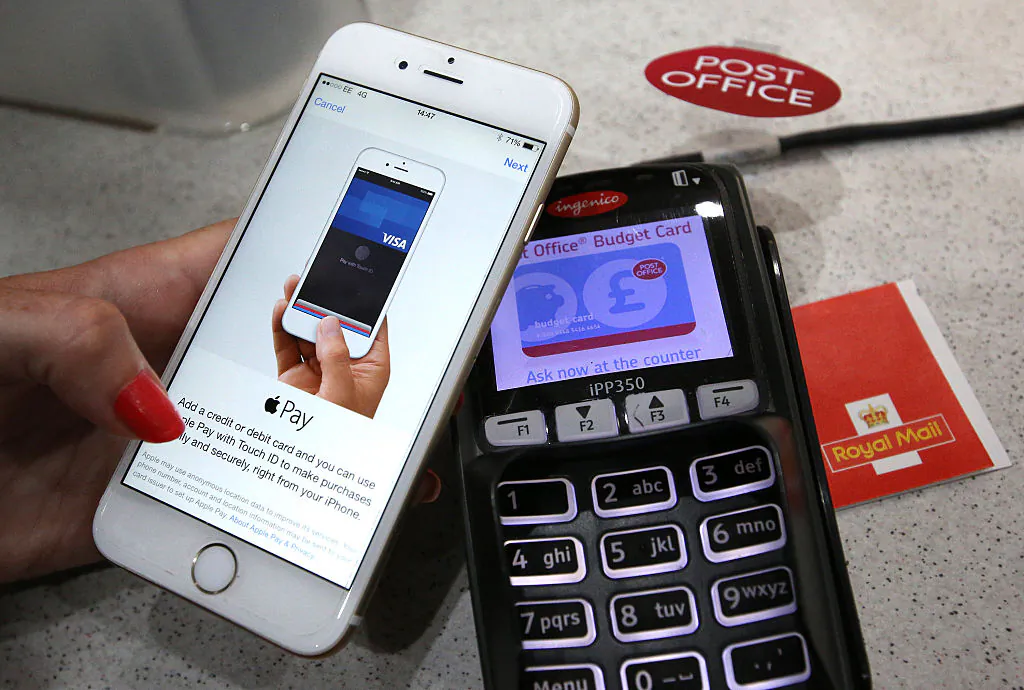 An iPhone is used to make an Apple Pay purchase at The Post Office in London, England, on July 14, 2015. (Peter Macdiarmid/Getty Images)