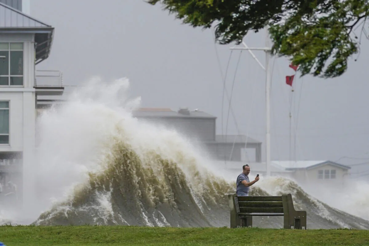 A man takes pictures of high waves along the shore of Lake Pontchartrain as Hurricane Ida nears, in New Orleans, La., on Aug. 29, 2021. (Gerald Herbert/AP Photo)