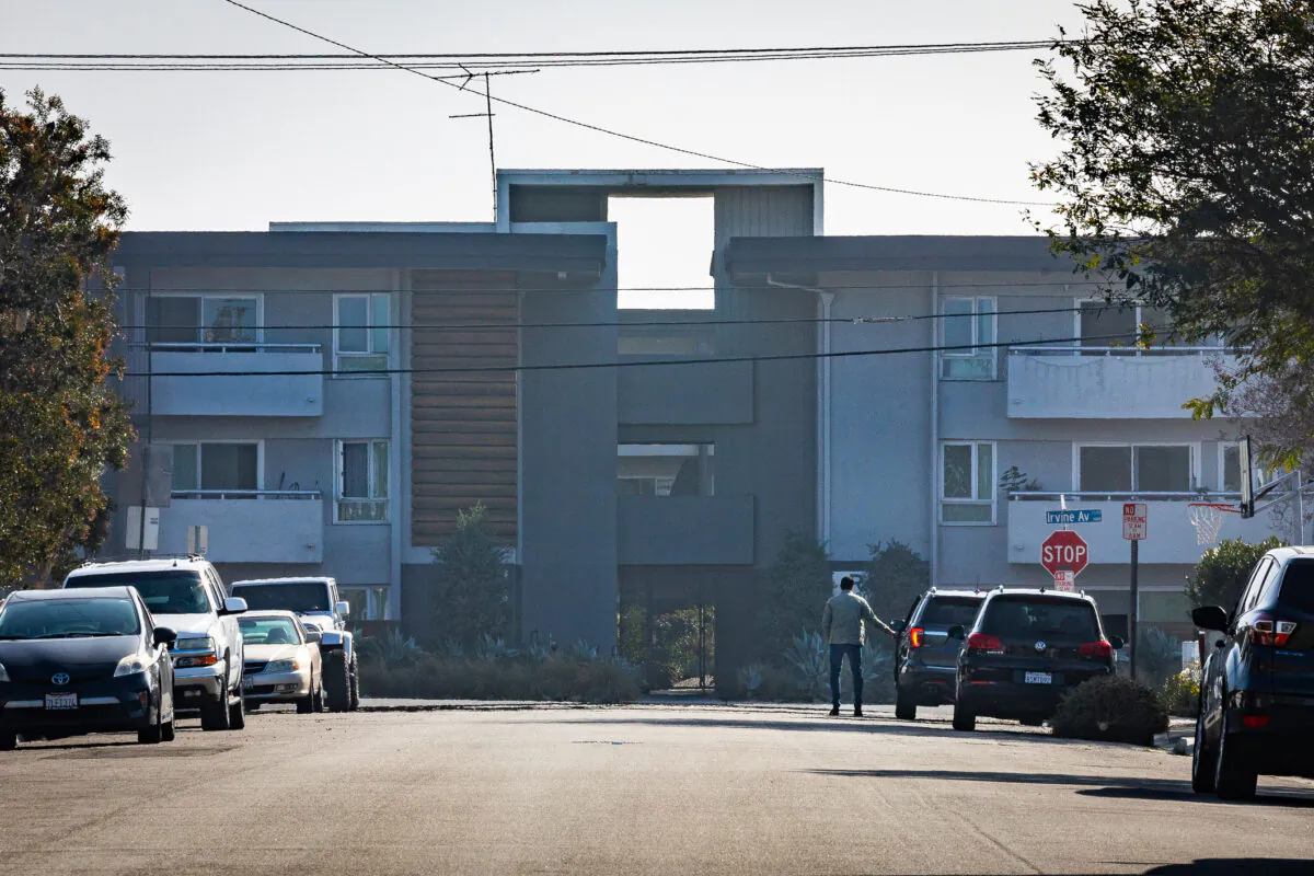 A man stand by his car in front of his home facing an apartment complex in Newport Beach, Calif.,on Jan. 8, 2021. (John Fredricks/The Epoch Times)