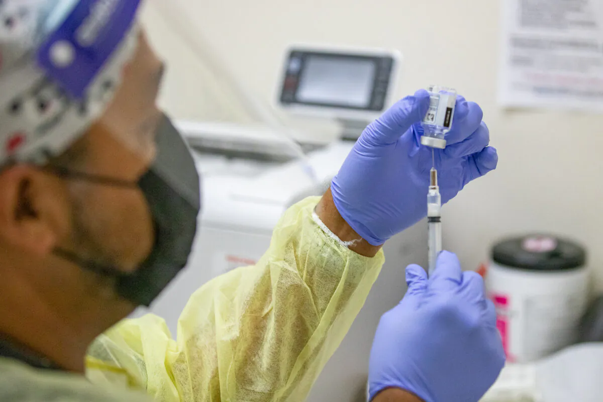 A medical volunteer prepares the Moderna CCP virus vaccination for a patient at Lestonnac Free Clinic in Orange, Calif., on March 9, 2021. (John Fredricks/The Epoch Times)