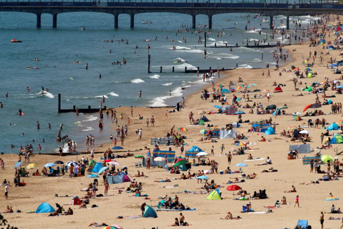 Sunbathers enoy the warm weather on the beach near Boscombe Pier in Bournemouth, south England on May 30, 2020. (Adrian Dennis/AFP via Getty Images)
