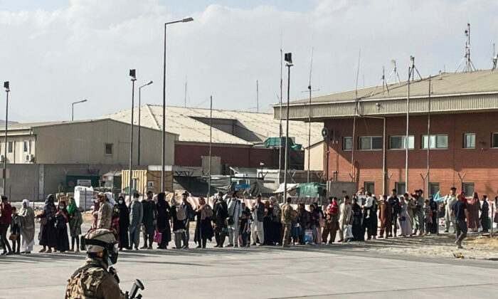 Afghan evacuees queue before boarding one of the last Italy's military aircraft C130J during evacuation at Kabul's airport, Afghanistan, on Aug. 27, 2021. (Italian Ministry of Defence/Handout via Reuters)