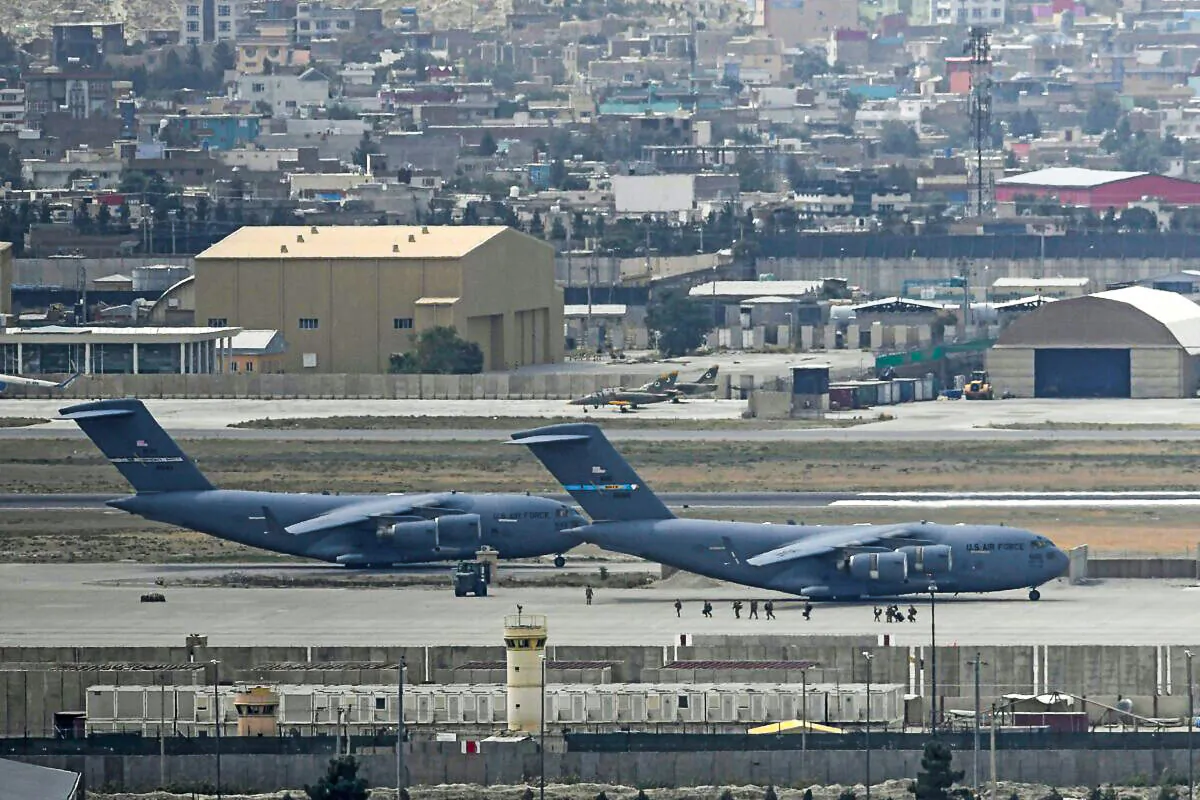 US soldiers walk through the tarmac to board an US Air Force aircraft at the airport in Kabul on August 30, 2021. - Rockets were fired at Kabul's airport on August 30 where US troops were racing to complete their withdrawal from Afghanistan and evacuate allies under the threat of Islamic State group attacks. (Photo by Aamir QURESHI / AFP) (Photo by AAMIR QURESHI/AFP via Getty Images)