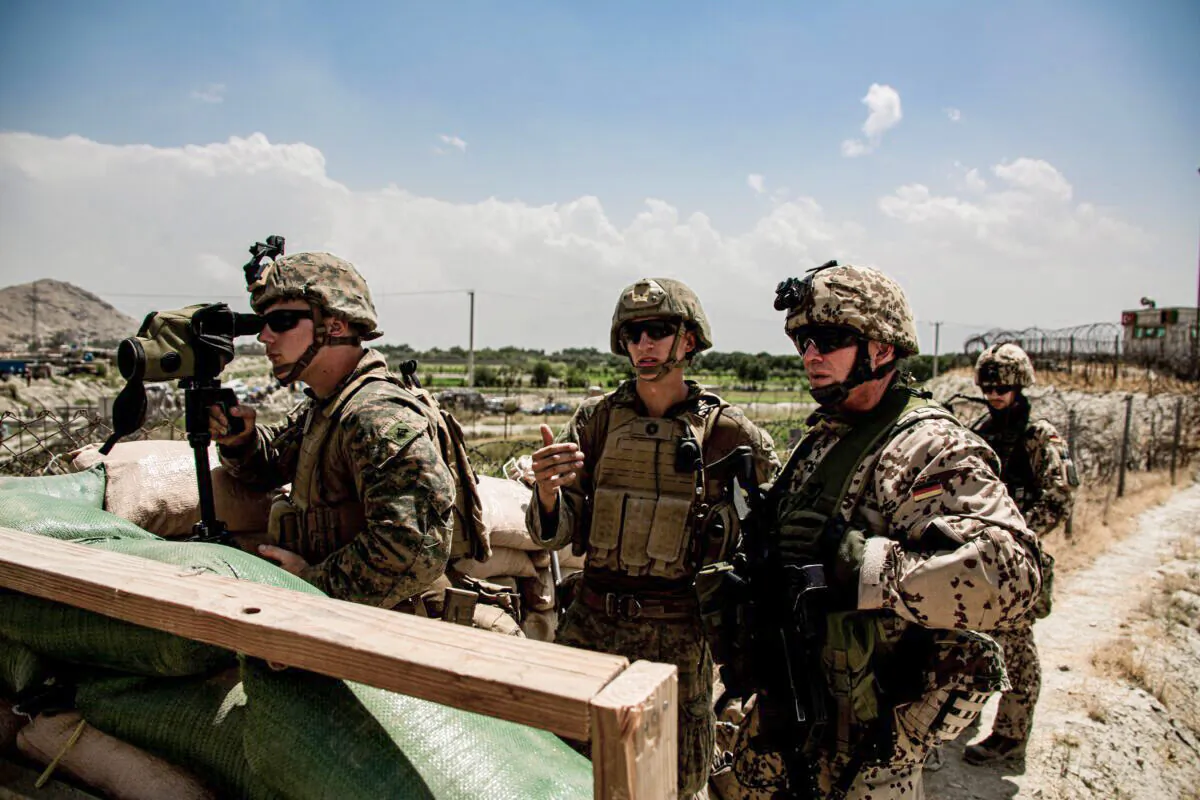 U.S. Marines and a German service member watch an entry gate during an evacuation at Hamid Karzai International Airport, Kabul, Afghanistan, on Aug. 28, 2021. (U.S. Marine Corps/Cpl. Davis Harris/Handout via Reuters)