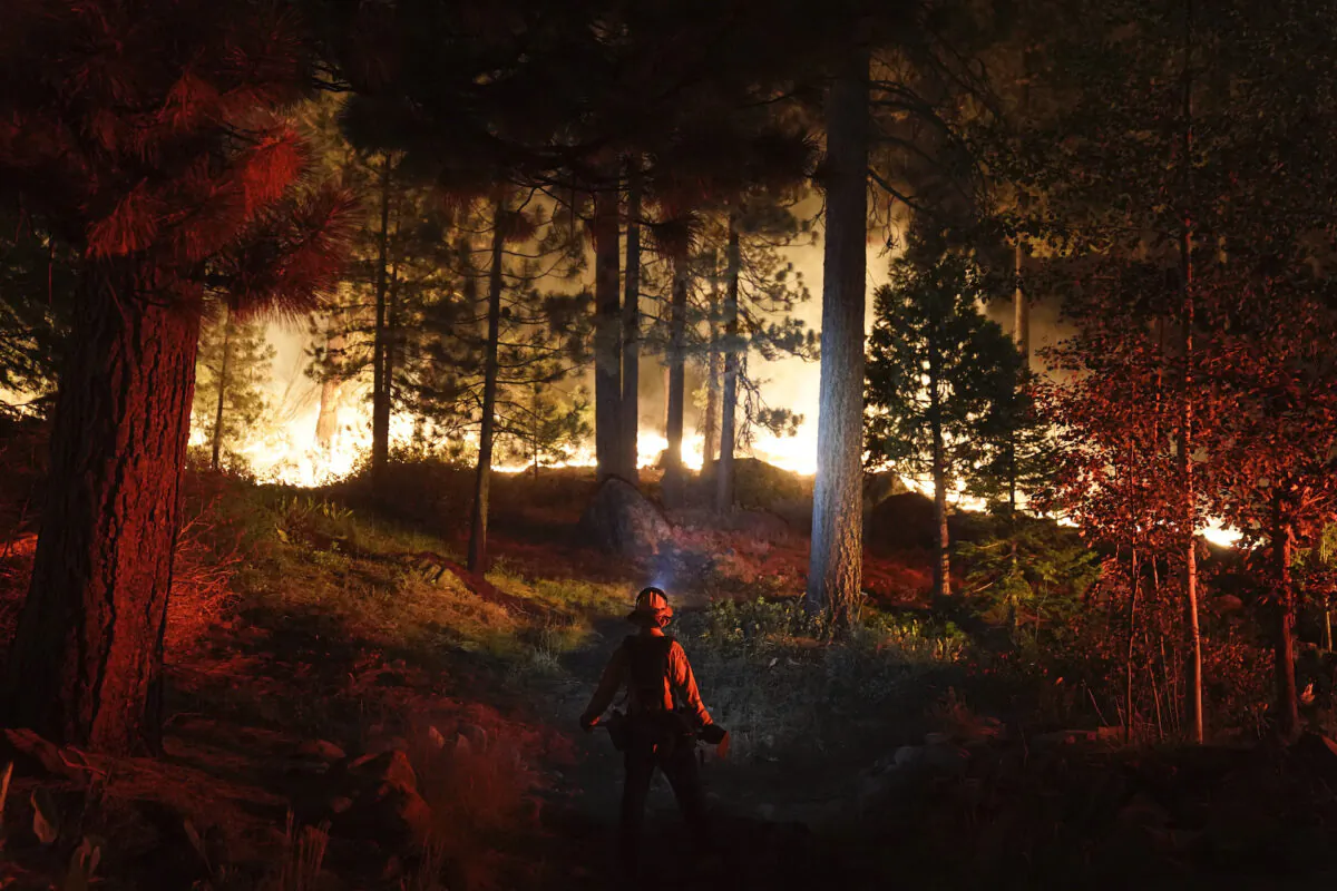 A firefighter monitors the Caldor Fire burning near homes in South Lake Tahoe, Calif., on Aug. 30, 2021. (Jae C. Hong/AP Photo)