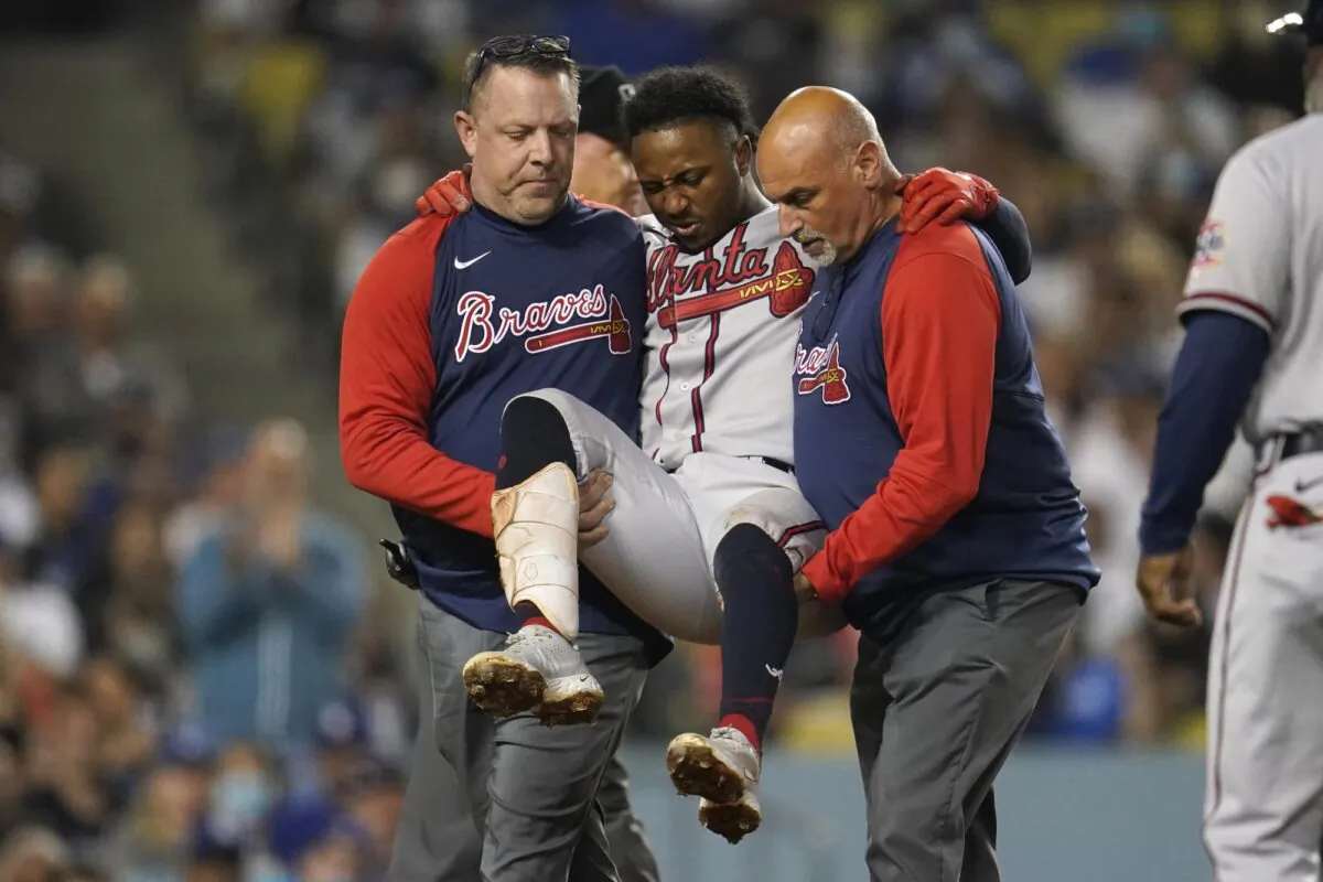 Atlanta Braves' Ozzie Albies is carried off the field after an injury during the fifth inning of the team's baseball game against the Los Angeles Dodgers in Los Angeles on Aug. 31, 2021. (Marcio Jose Sanchez/AP Photo)