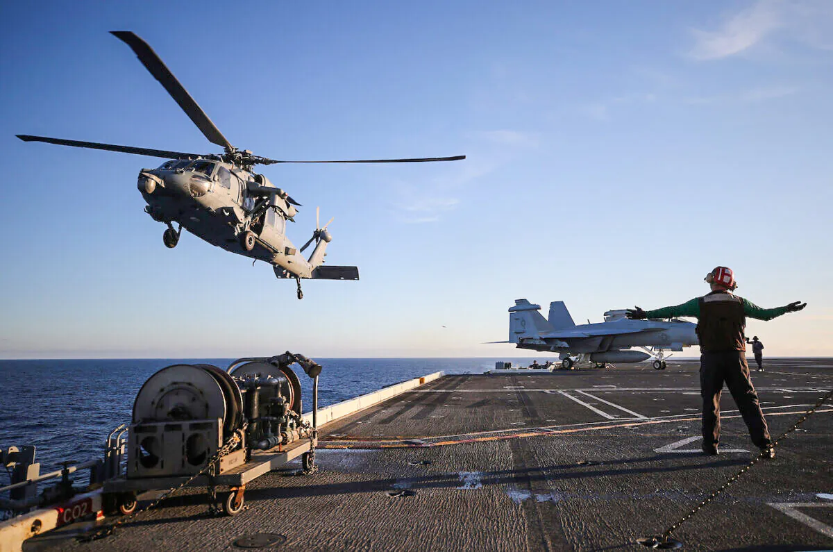 A U.S. Navy MH-60S helicopter descends to land on the flight deck of the USS Nimitz aircraft carrier while at sea off the coast of Baja California, Mexico, on Jan. 18, 2020. (Mario Tama/Getty Images)
