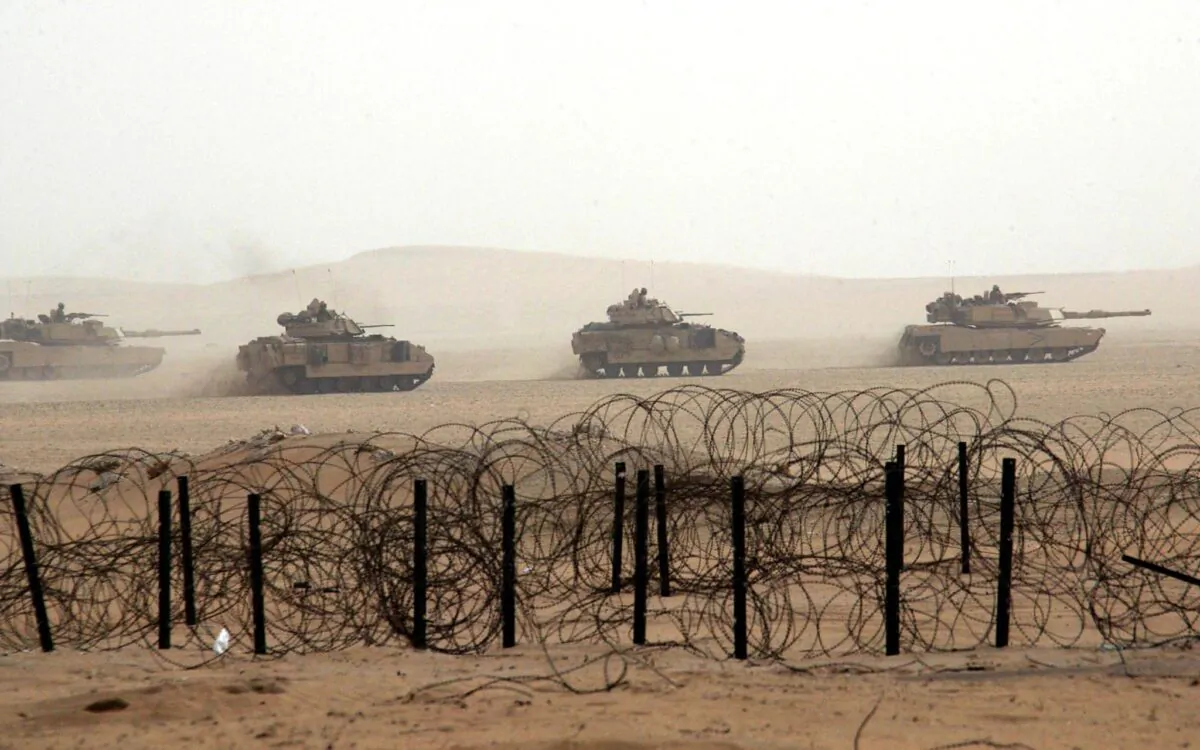 U.S. army tanks roll through the Kuwaiti desert during maneuvers, some 15 miles from the Iraqi border, Dec. 21, 2002. (Rabih Moghrabi/AFP via Getty Images)