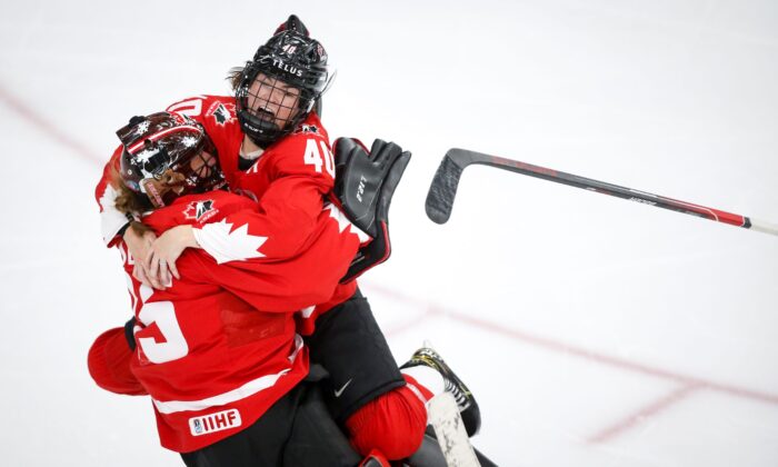 Canada goalie Ann-Renee Desbiens (L) and teammate Blayre Turnbull celebrate the team's overtime win against the United States in the IIHF hockey women's world championships title game in Calgary, Alberta, Canada, on Aug. 31, 2021. (Jeff McIntosh/The Canadian Press via AP)