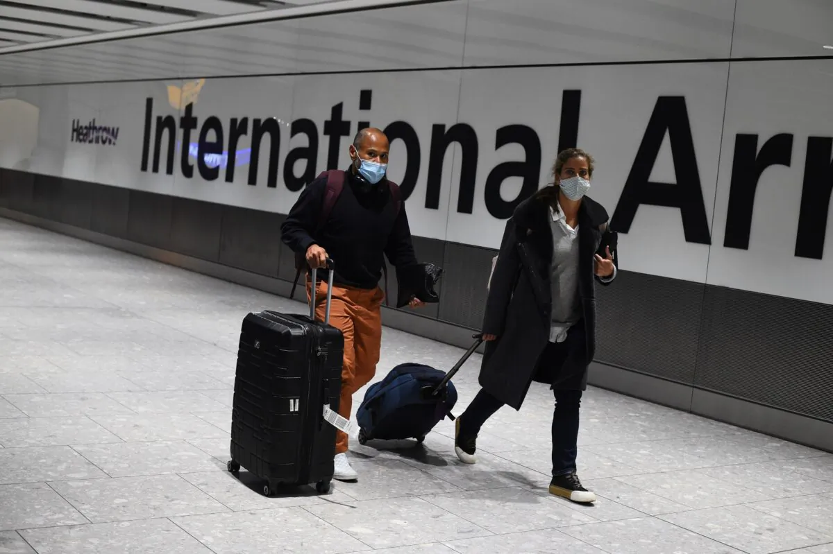 Passengers walk with luggage through the Arrival Hall of Terminal 5 at London's Heathrow Airport on Jan. 18, 2021. (Kirsty O’Connor/PA)