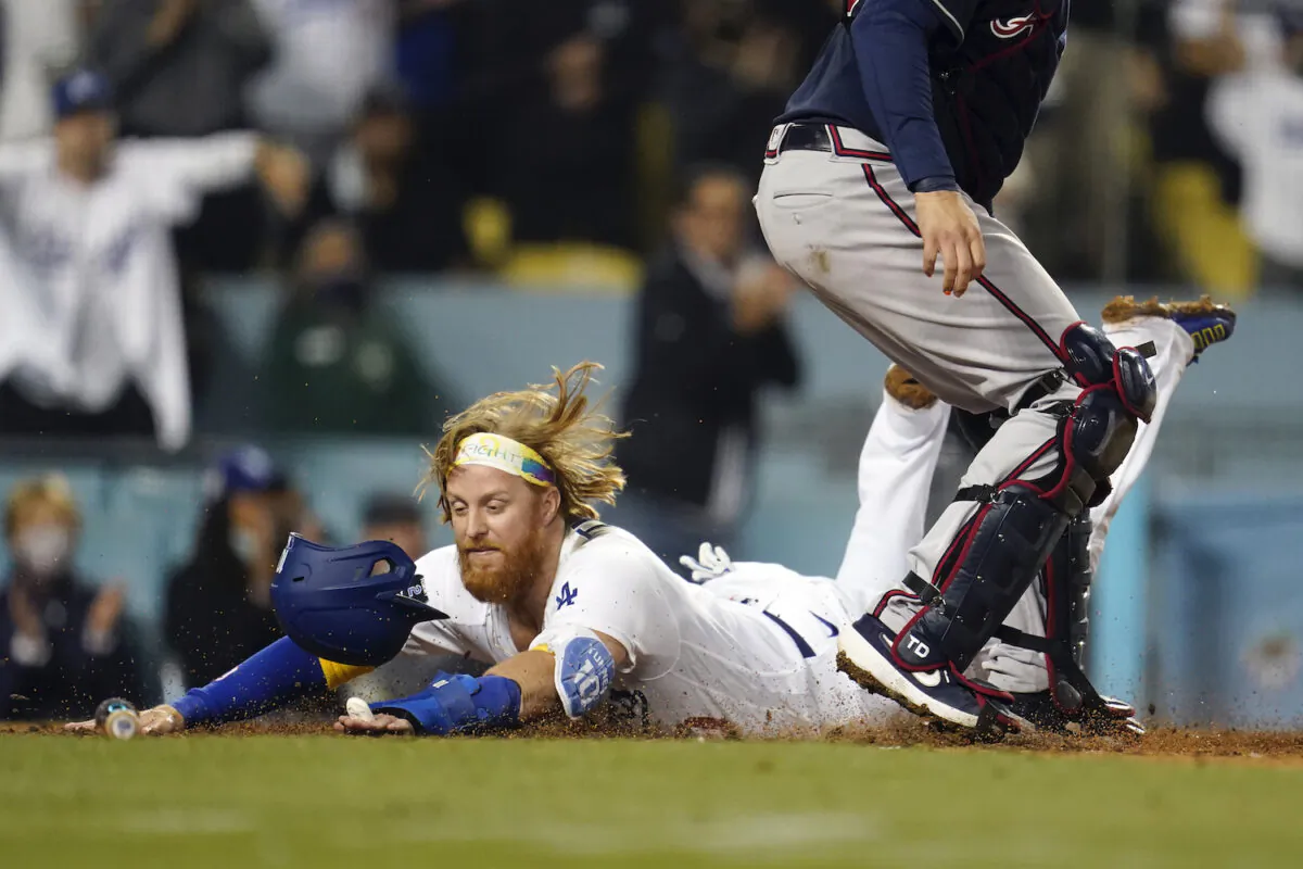 Los Angeles Dodgers' Justin Turner scores past Atlanta Braves catcher Travis d'Arnaud on a single by AJ Pollock during the eighth inning of a baseball game in Los Angeles on Sept. 1, 2021. (AP Photo/Marcio Jose Sanchez)