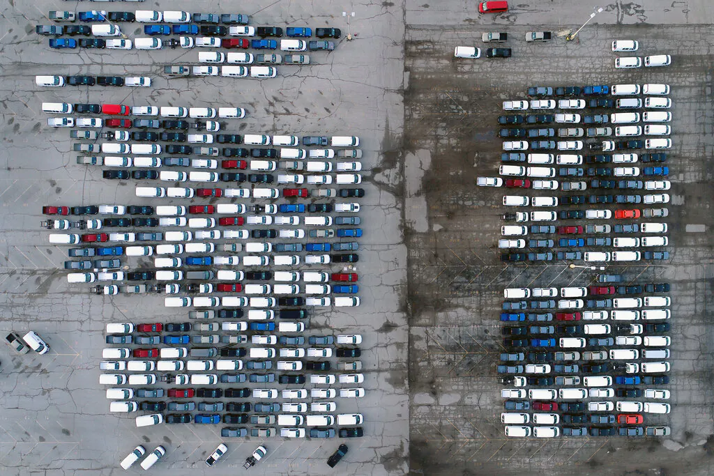 Mid-sized pickup trucks and full-size vans are seen in a parking lot outside a General Motors assembly plant where they are produced in Wentzville, Mo, on March 24, 2021. (Jeff Roberson/AP Photo)