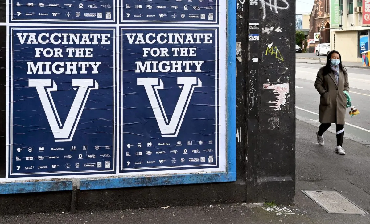 A person walks past posters encouraging people to get vaccinated in Melbourne, Australia, on Aug. 31, 2021(William West/AFP via Getty Images)