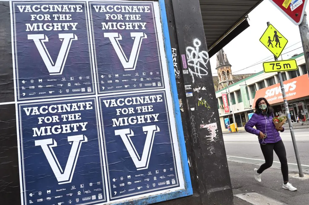 A person walks past posters encouraging people to get vaccinated in Melbourne, Australia on Aug. 31, 2021. (William West/AFP via Getty Images)