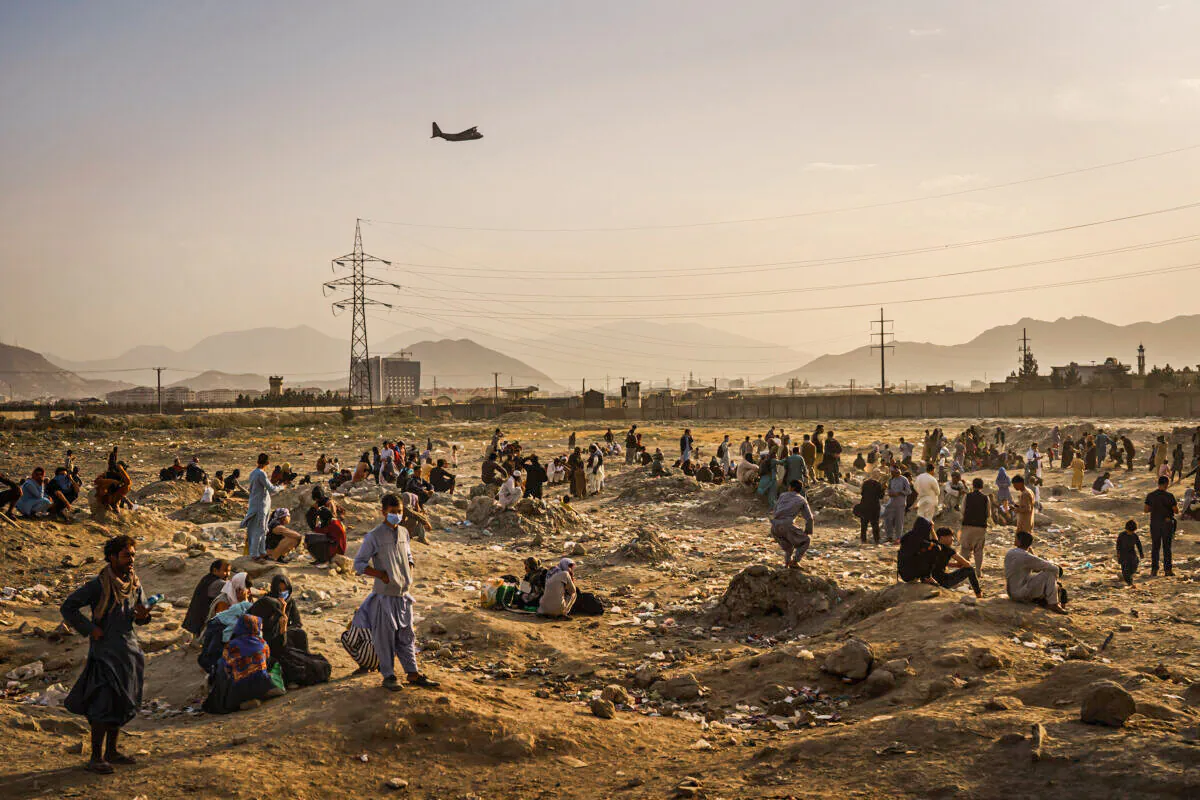 A military transport plane launches off while Afghans left behind watch in Kabul, Afghanistan, on Aug. 23, 2021. (Marcus Yam/Los Angeles Times/TNS)