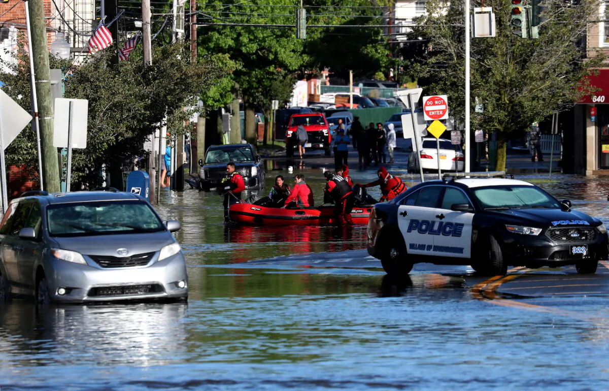 First responders pull local residents in a boat as they perform rescues of people trapped by floodwaters after the remnants of Tropical Storm Ida brought drenching rain,  flash floods and tornadoes to parts of the northeast in Mamaroneck, New York, on Sept. 2, 2021. (Mike Segar/Reuters)