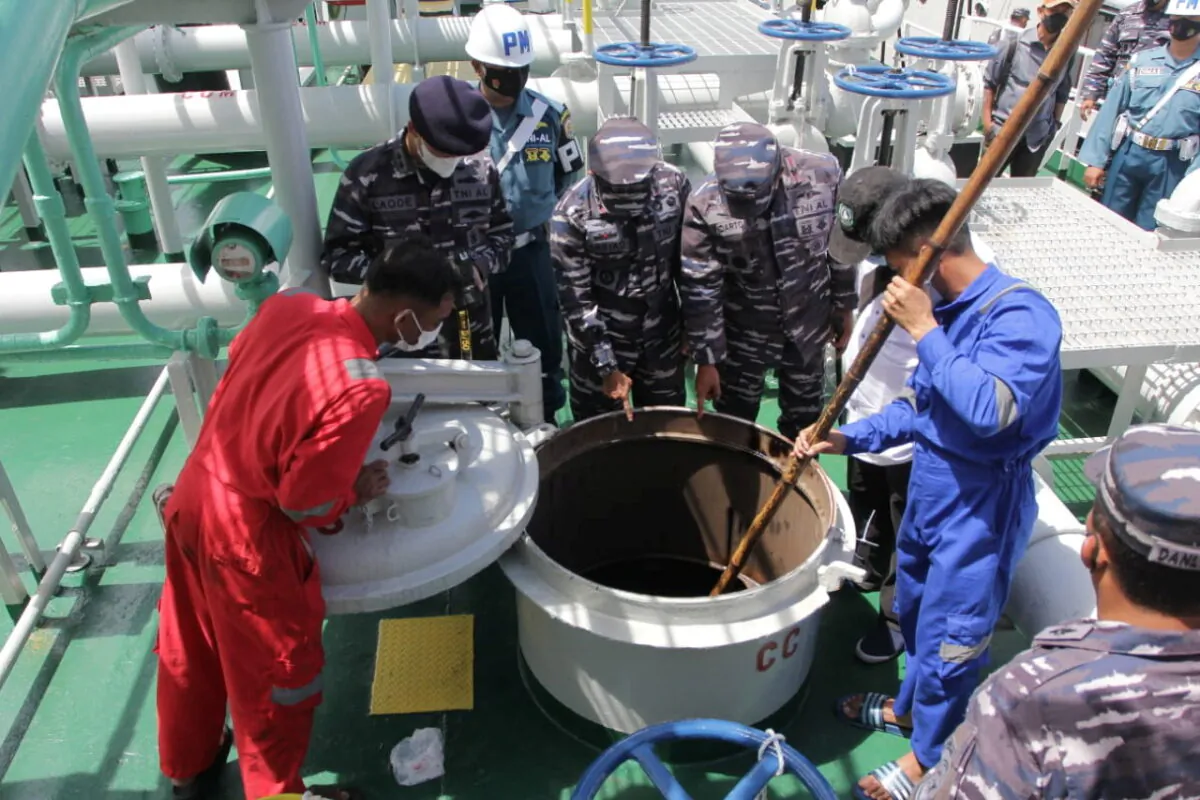 Indonesian Navy personnel inspect a tank of the Panamanian-flagged tanker, the MT. Zodiac Star, that was seized on suspicion of conducting illegal activities in the country's waters and carrying more than 4,000 tons of oil without valid permits, in the waters off Batam, Riau islands, Indonesia, on Sept. 1, 2021. (Courtesy Indonesian Navy/Handout via Reuters)
