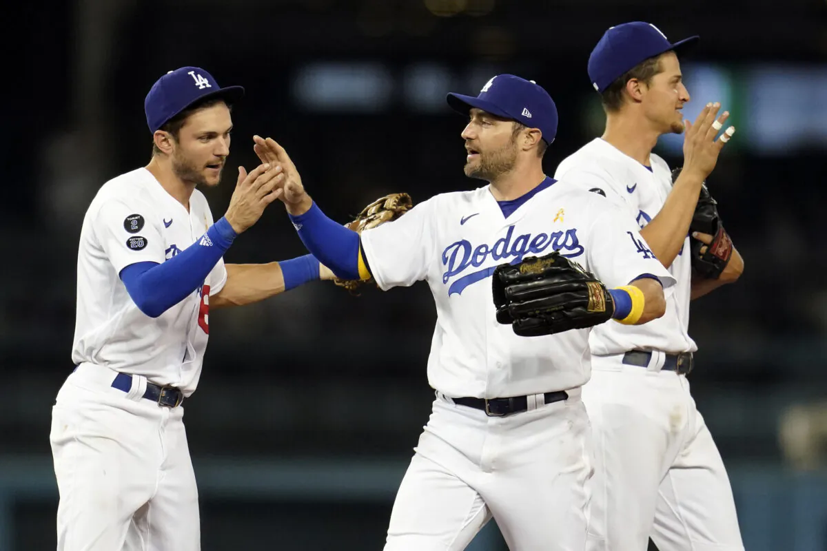 Los Angeles Dodgers' Trea Turner, AJ Pollock and Corey Seager, from left, celebrate the team's win over the Atlanta Braves in a baseball game in Los Angeles on Sept. 1, 2021. (AP Photo/Marcio Jose Sanchez)