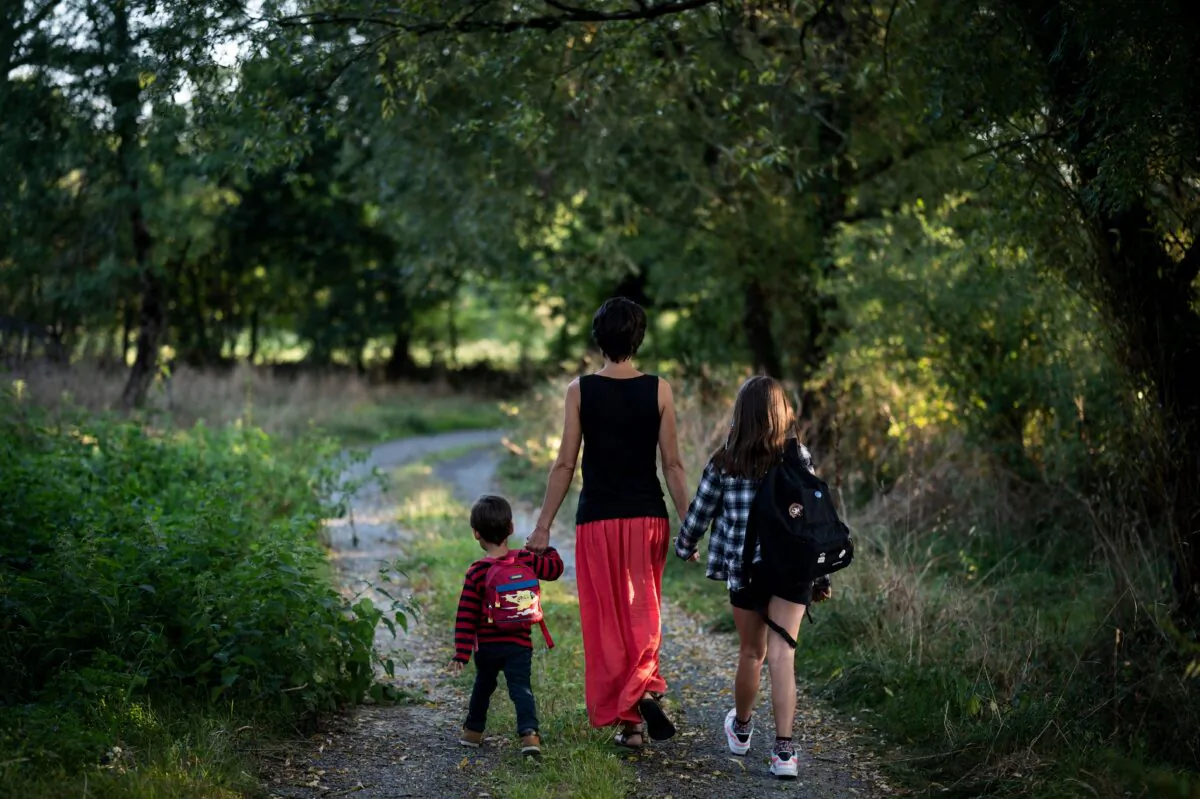 A mother walks toward school with her children in Lavau-sur-Loire, western France on Sept. 2, 2021 (Loic Venance/AFP via Getty Images)
