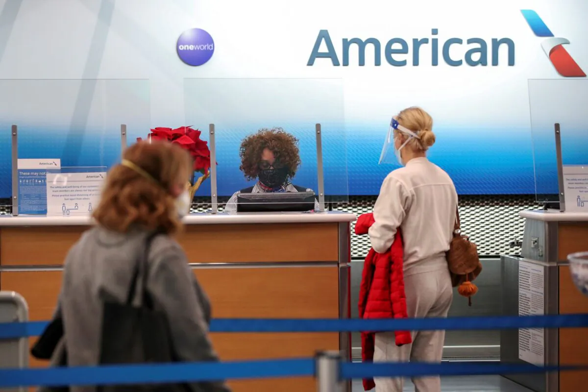 American Airlines agent helps a customer to check in for her flight at O'Hare International Airport ahead of the Thanksgiving holiday during the coronavirus disease (COVID-19) pandemic, in Chicago, Ill., on Nov. 25, 2020. (Kamil Krzaczynski/Reuters)